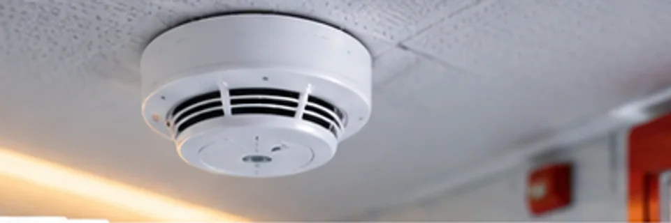 Imagen ilustrativa de un detector profesional instalado en el cielo de un pasillo de edificio.